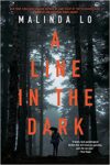 the new paperback cover of A Line in the Dark, showing a person in the woods